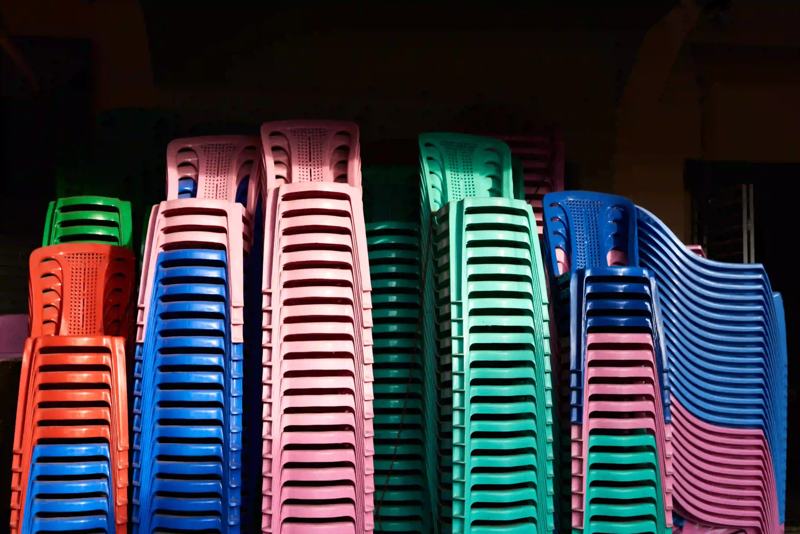 Chaises en plastiques empilées de couleurs différentes