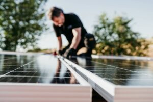 Homme installant des panneaux solaires